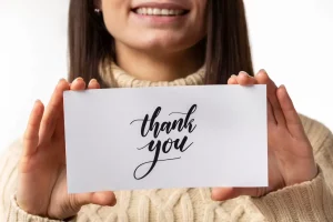This is a women holding a thank you page card.